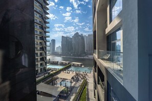 A high-rise building with a view of a river and modern skyscrapers in the background. - Luxury 1-Bedroom Apartment, Burj Khalifa Views & Infinity Pool, Dubai Mall (Dubai)