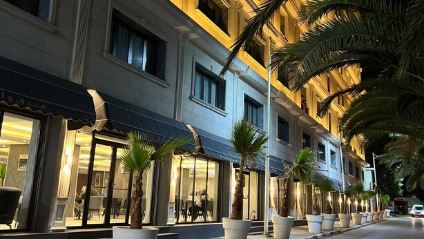 A hotel with multiple floors, large windows, and a well-lit facade. - Hôtel EL AZIZ INN (Algiers)