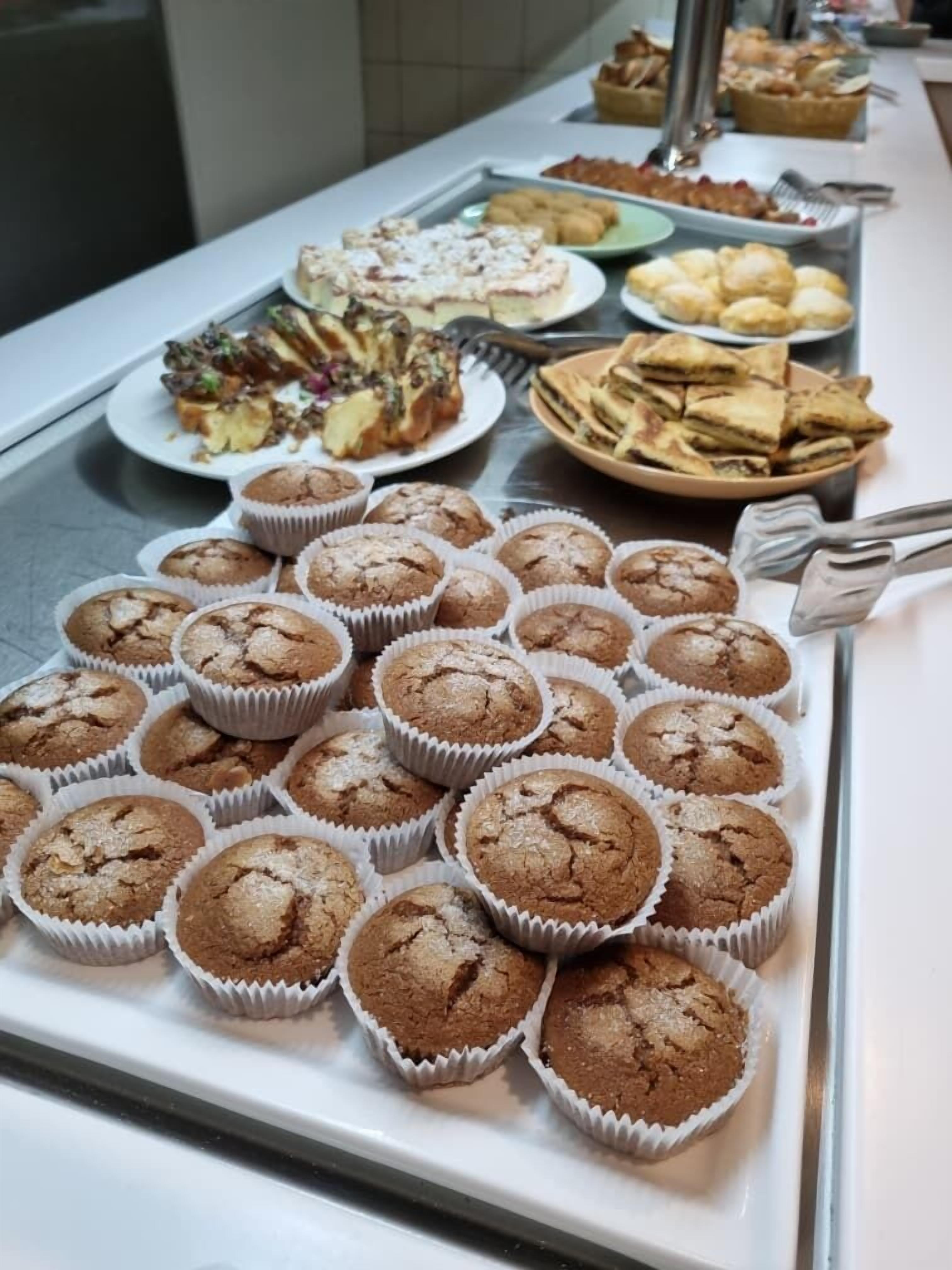 En buffé med ett urval av olika bakverk, inklusive muffins, smörgåsar och andra småbröd.