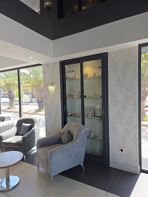 Un intérieur moderne comprenant un coin salon, une vitrine et de grandes fenêtres.
