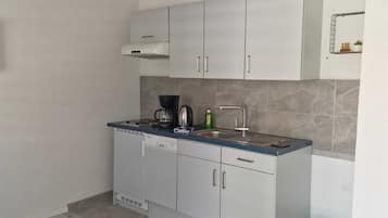 Compact kitchen with dishwasher, sink, and coffee maker.