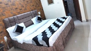 Une chambre à coucher comprenant un lit, une tête de lit, une table de chevet et un miroir.
