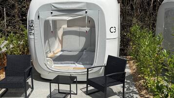 Une tente avec un code QR, portant l’inscription « C3 », et deux chaises noires devant.