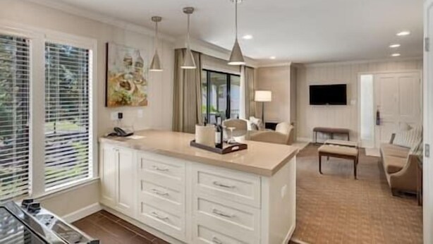 A modern kitchen with a large island, pendant lights, and a dining area with a bench. - Napa Valley Getaway in Silverado (Napa)