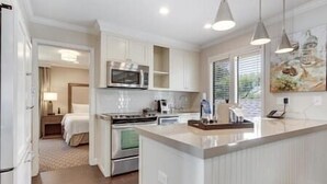 A modern kitchen with white cabinetry, a central island, and pendant lighting. - Napa Valley Getaway in Silverado (Napa)