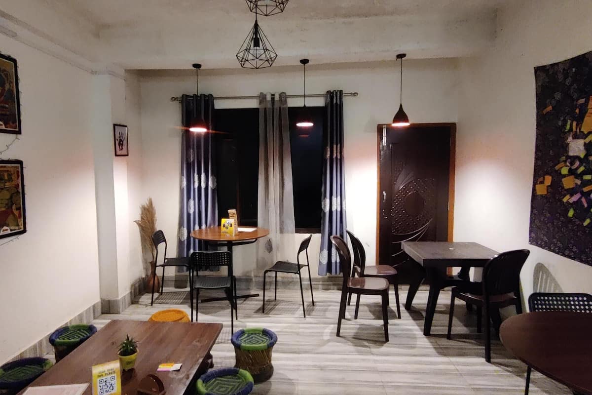 A dining area with a wooden table, chairs, and a hanging light fixture.