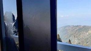 A view through a window with a mountain landscape. - The Local Tribe Homestay Cafe & Hostel (Darjeeling)