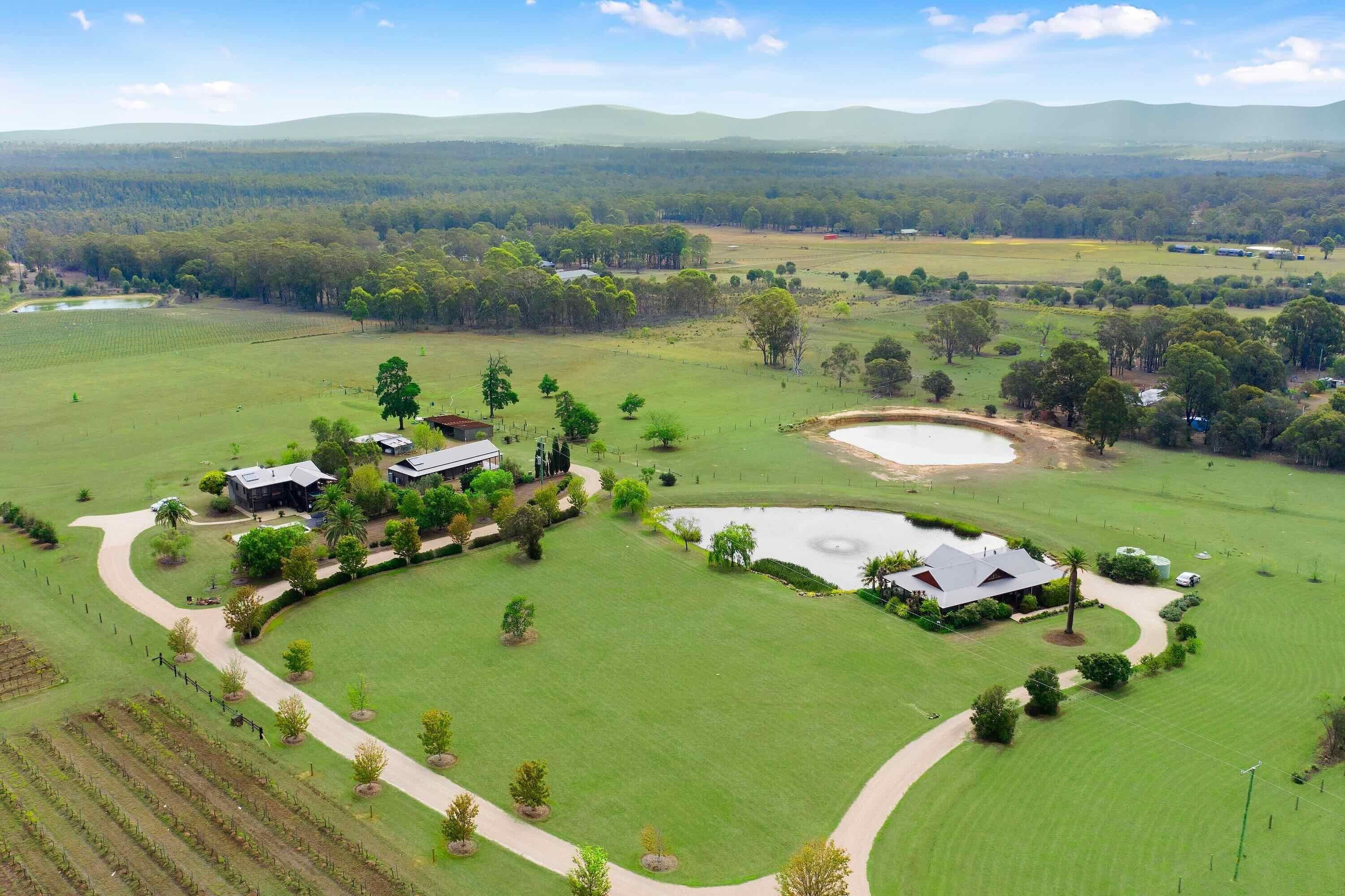 A golf course with a clubhouse, a pond, and surrounding fields.