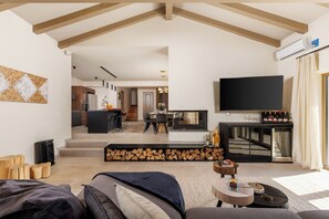 A modern living room with a sofa, a coffee table, and a TV. There is a kitchen in the background with a dining area. - Sun  Spalato Villa Teranina (Jadruhi)