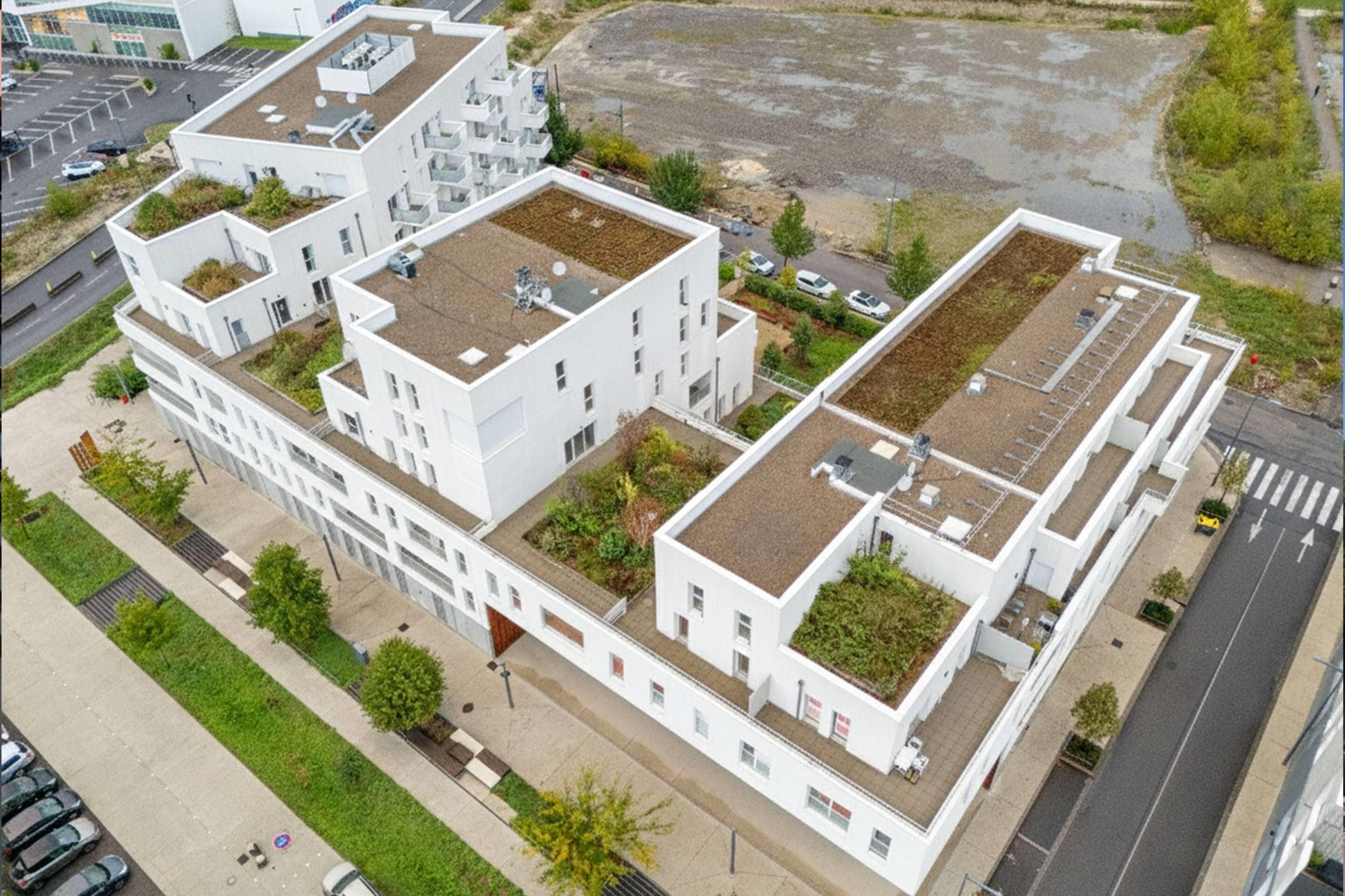 A modern multi-story building with flat roofs, large windows, and a central courtyard.
