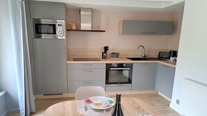Cocina compacta con microondas, horno y lavabo.