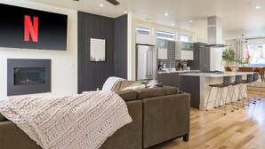 A modern living room with a fireplace, a sofa, and a TV mounted on the wall.