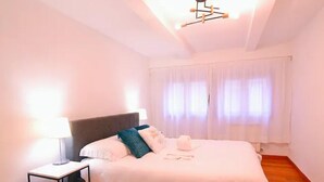 Una camera da letto con un letto, un comodino, una lampada e un lampadario.