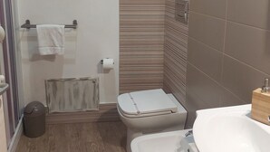 Een badkamer met toilet, bidet en wastafel.