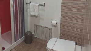 Een badkamer met een douche, toilet en een handdoekhouder.