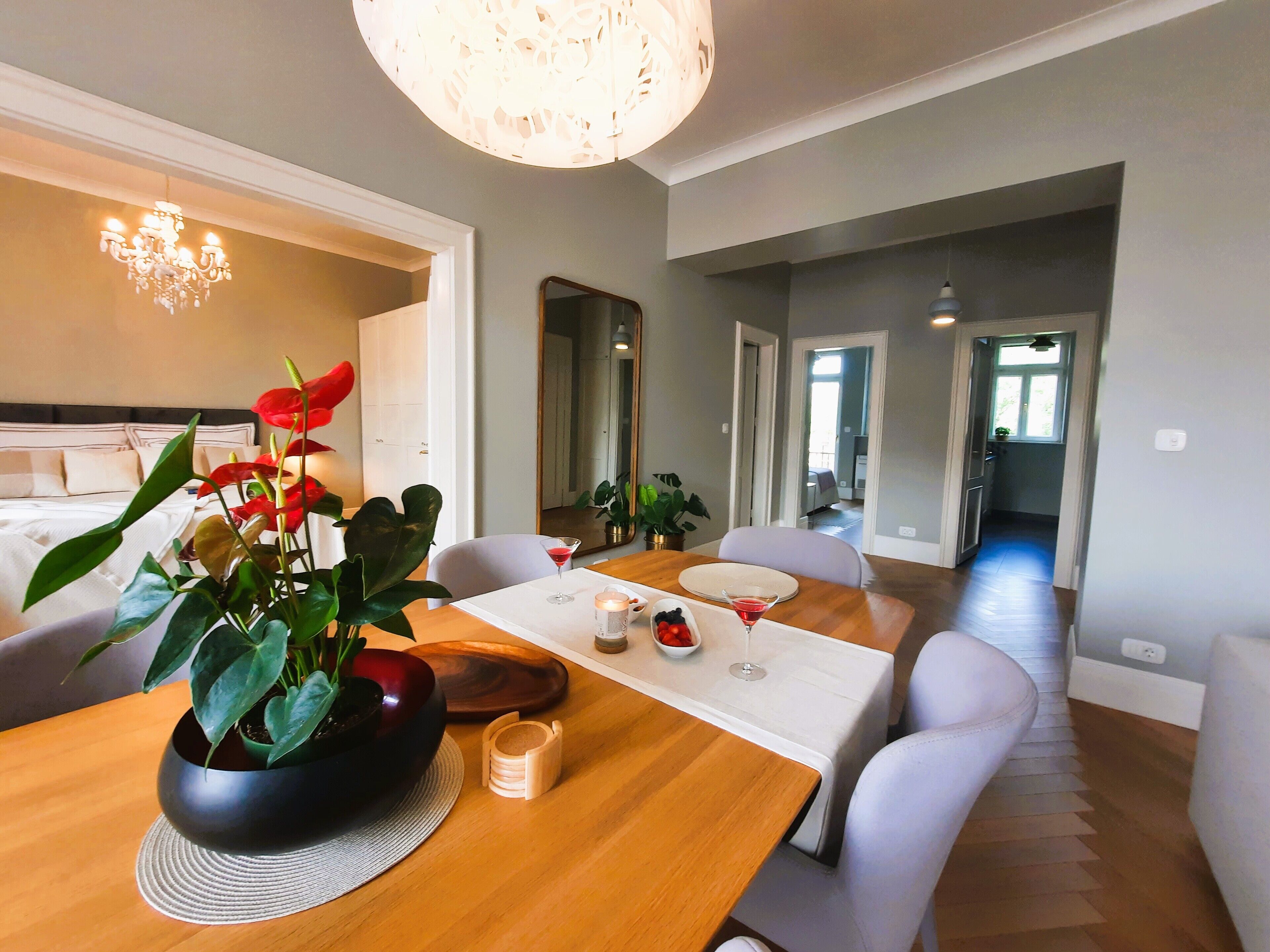 A modern dining area with a wooden table, white chairs, and a potted plant.