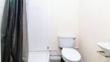 Une petite salle de bain avec des toilettes, un lavabo et une baignoire.