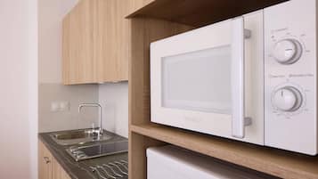 A kitchen with a built-in microwave, a sink, and a stainless steel faucet.