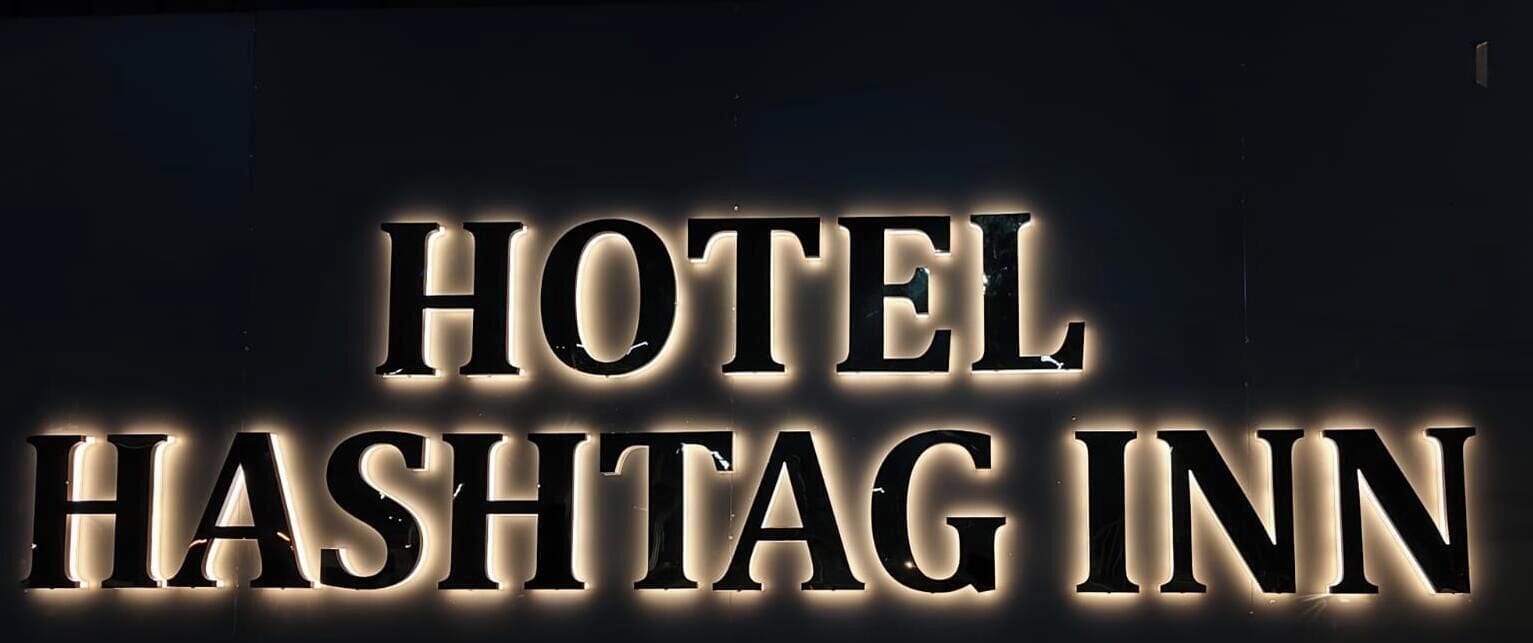 A sign with the words "HOTEL" and "HASHTAG INN" illuminated in large, bold letters.