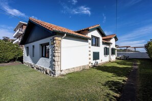 Stunning single-story home with a sloped roof and stone foundation, set amidst a beautifully manicured lawn.
