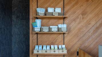 A wooden wall with three shelves displaying various packaged goods.