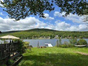 A lakeside view with a wooden deck, a hammock, and a grassy area. - Beautiful 6 Bedroom Lakefront Home w/ Own Dock and beautiful Lake Views<br>Please note that this home does not have air conditioning. <br>Box fans are provided and because of our proximity to the lake, it is cooler in the evenings. (Lebanon)