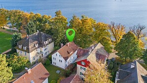 A residential area with houses, a green marker, and a body of water in the background. - LAKE Loft Marina (Überlingen)