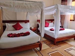 A hotel room with two beds, each with a canopy, white bedding, and red pillows. - Elboran Resort and spa (Isiolo)