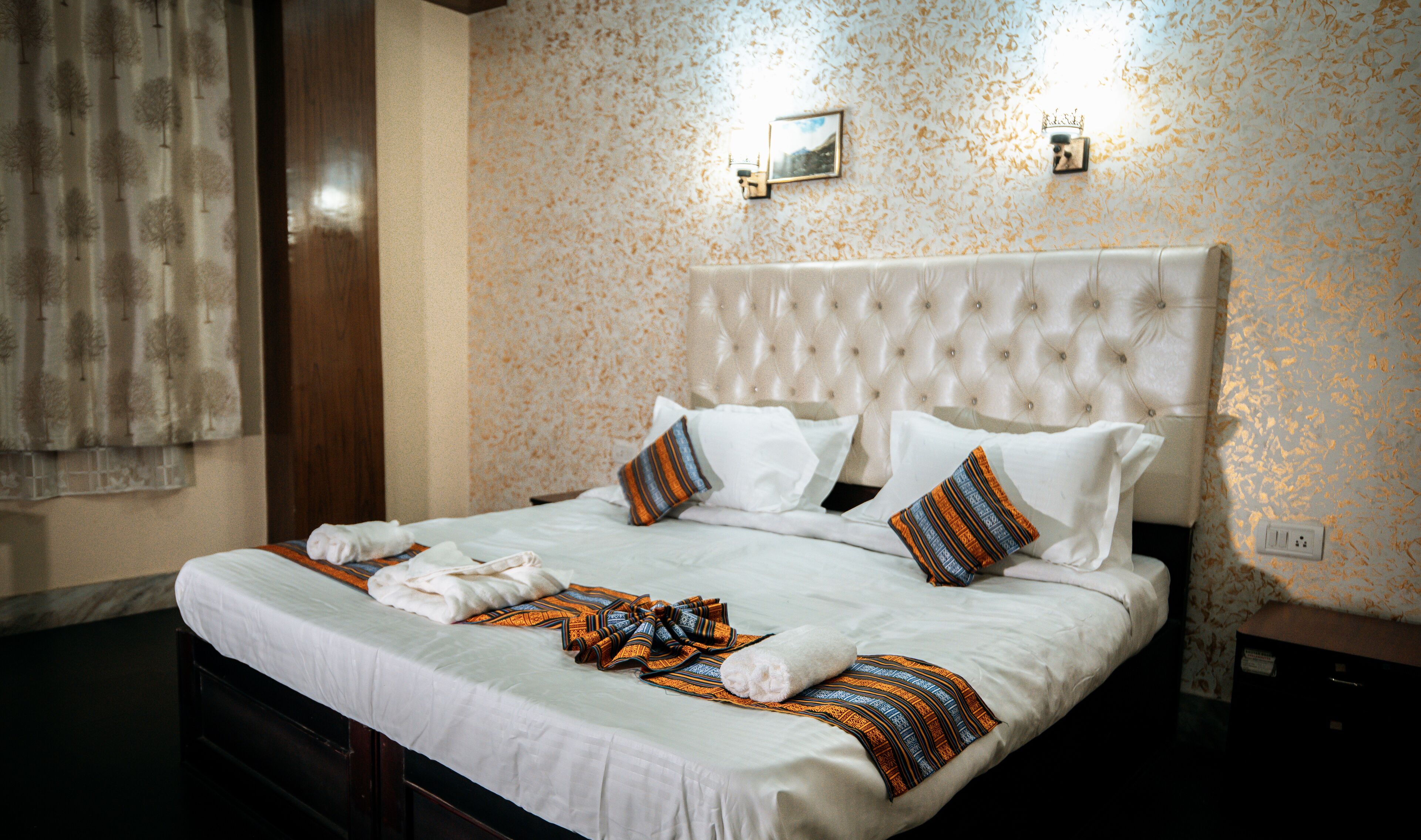A neatly made bed with a white duvet, two pillows, and a striped blanket.