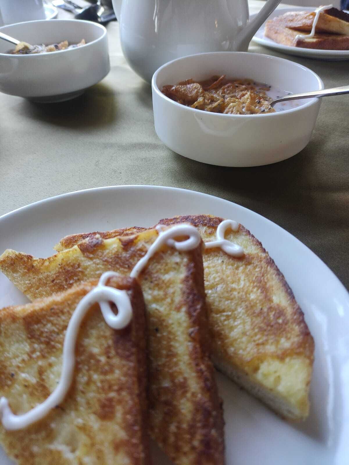 Une table mise pour le petit-déjeuner avec des tartines et un bol de soupe.