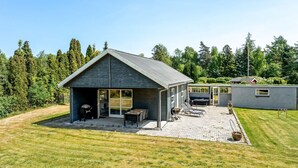 A modern house with a patio area, a barbecue, and a covered seating area. - "Agneta" - 1km from the sea by Interhome (Væggerløse)