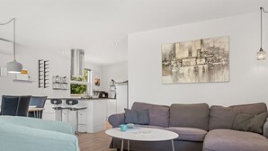 A modern living room with a grey sofa, a round coffee table, and a dining area with a white table and chairs. - "Agneta" - 1km from the sea by Interhome (Væggerløse)