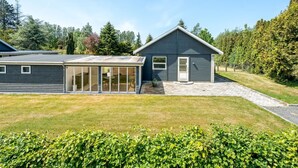 A modern two-story house with a large glass-enclosed patio area and a separate garage. - "Agneta" - 1km from the sea by Interhome (Væggerløse)