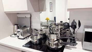 A modern kitchen with stainless steel appliances, including a stove, toaster, and kettle.