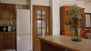 Eine Küche mit Holzausstattung, einem weißen Kühlschrank und einem Holztisch mit einer Vase.