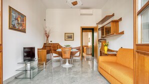 Un soggiorno moderno con tavolo da pranzo in vetro, mobili in legno e un divano.