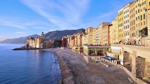 A coastal town with colorful buildings, a beach, and a prominent tower. - Gorgeous apartment in Camogli with WiFi (Camogli)