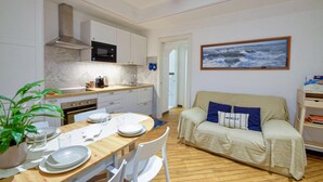 A compact living space with a kitchenette, a dining area, and a sofa with a nautical-themed pillow. - Gorgeous apartment in Camogli with WiFi (Camogli)