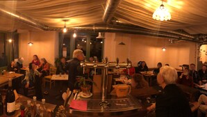 A restaurant with a central bar, tables, chairs, and hanging lights. - TAVARN TY GAR (Hennebont)