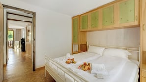 Camera d'albergo con un letto grande, una testiera in legno e vista sul corridoio.