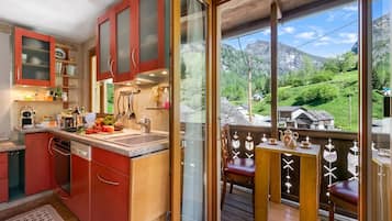 A kitchen with a view of a mountainous landscape.
