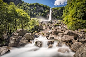 A waterfall surrounded by rocks and lush greenery. - Casa Andy 1 Val Lavizzara With Views for Four (Lavizzara)