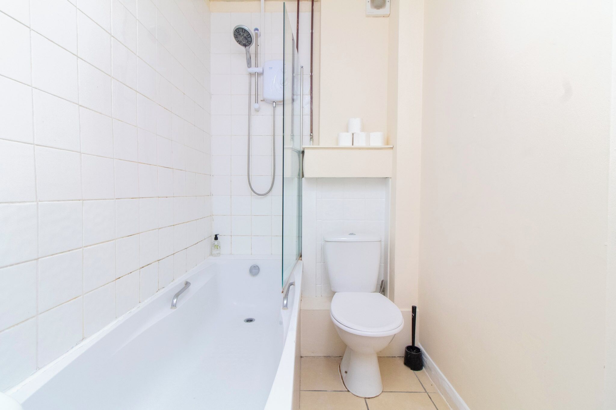 A bathroom with a bathtub, toilet, and glass-enclosed shower.