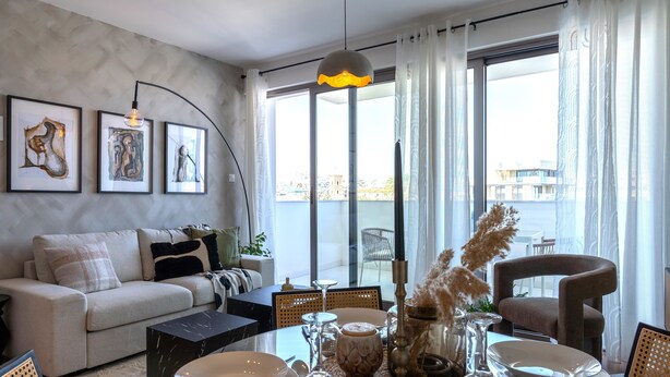 A modern living room with a sofa, dining table set, and artwork on the wall. - Pauhad 3 - Larnaca Studios & Apts (Larnaca)