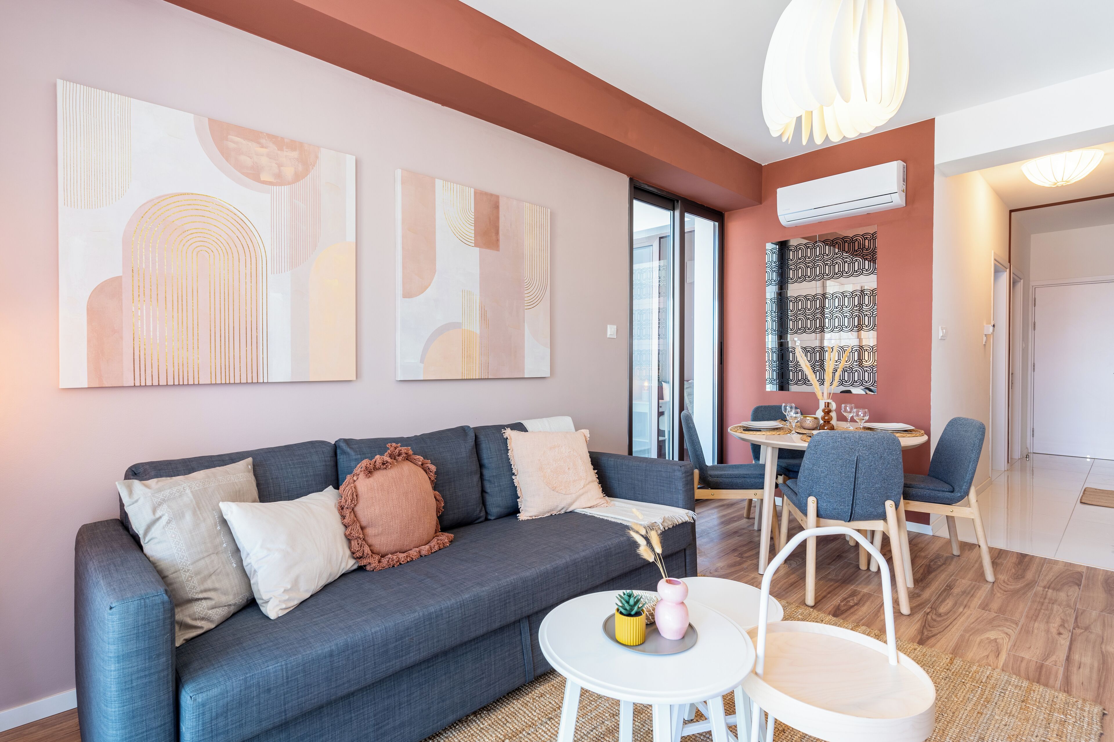 A modern living room with a grey sofa, white coffee table, and abstract wall art.