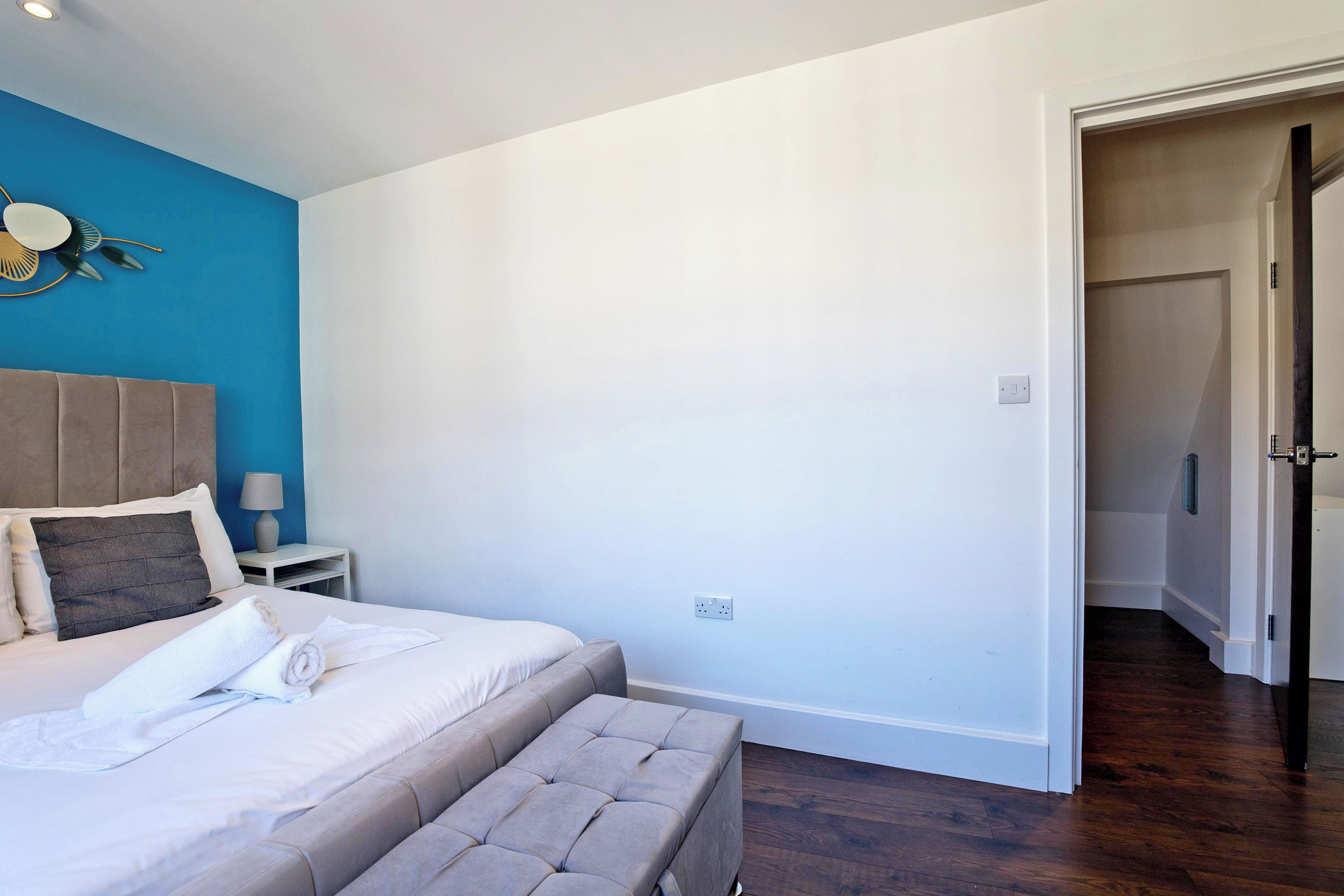 A bedroom with a bed, bedside table, and a wall-mounted decorative item.