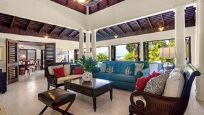 A spacious living area with a high ceiling, large windows, and a view of the outdoors. - Half Hill 3BR (Montego Bay)
