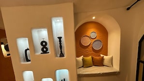 A modern interior with a wall-mounted light fixture and a decorative wall with geometric patterns. - SelkA Pansiyon (Ayvalik)