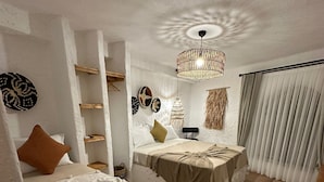 A room with two beds, a hanging light fixture, and a large window with curtains. - SelkA Pansiyon (Ayvalik)