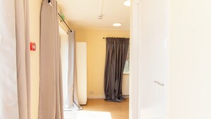 Un pasillo con cortinas, un radiador y una puerta.